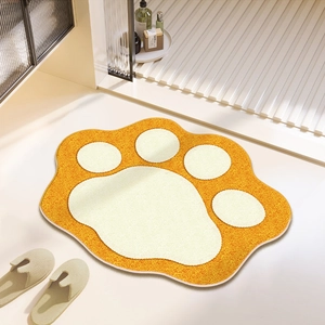 Top-down view of a plush orange cat paw bath mat placed by a clean glass shower door
