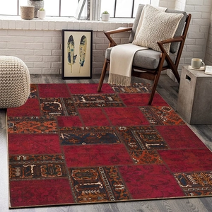 Detail of vintage patchwork rug with dark red geometric patterns on a wooden floor