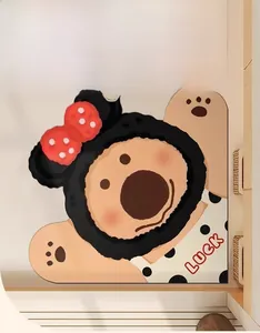 Dettaglio del tappeto a forma di orso antiscivolo con scritta luck e fiocco a pois