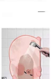 Detailed view of cleaning a pink pig shaped absorbent diatom mud non-slip bath mat