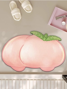 Detail of peach-shaped non-slip bath mat with soft tufted texture and pink gradient