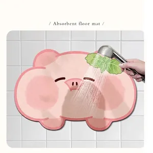 Pink cartoon pig absorbent diatom mud bath mat being rinsed with water on white tile
