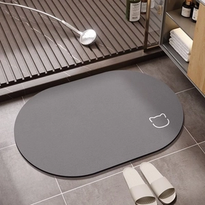 Detail of dark grey oval bath mat featuring a minimalist cat face and anti-slip texture