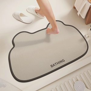 Irregular cloud-shaped diatom mud bath mat in cream with grey border and Bathing text