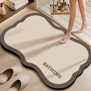Detail of irregular wave-shaped bathroom mat with Bathing text and non-slip texture