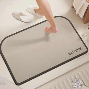 Detailed close-up of a minimalist beige diatom mud bath mat with gray non-slip edging