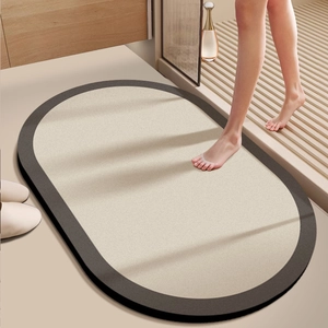 Detailed close-up of non-slip oval bath mat with beige center and dark coffee border