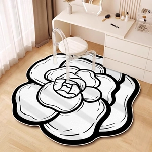 Detailed view of camellia shaped rug with bold black outlines on light wooden floors