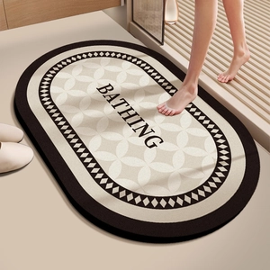 Detail of oval absorbent bath mat with BATHING text and geometric pattern in bathroom setup