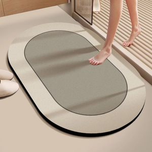 Detailed close-up of dual-color oval diatom mud bath mat with non-slip texture in modern bathroom