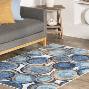 Detailed view of geometric blue and gold overlapping circles carpet on light wood floor