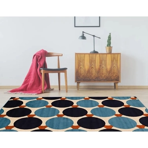 Detail of modern geometric carpet with blue and orange circles in a cozy living room scene