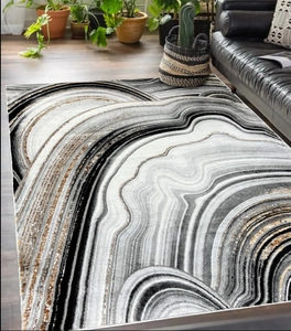 Detailed view of modern abstract marble texture rug with black and gold flow patterns