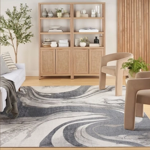 Detailed view of grey marble fluid texture rug under a velvet chair in a modern living room