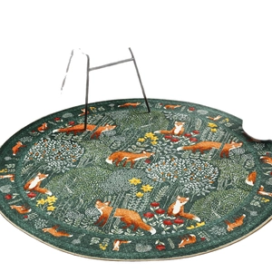 Modern round forest rug featuring orange fox pattern and trees on dark green ground