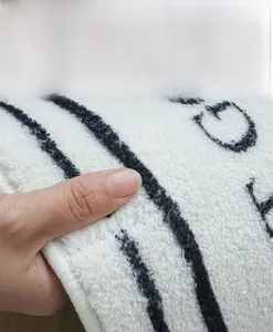 Close-up of soft plush faux cashmere rug showing dense texture and lettered patterns