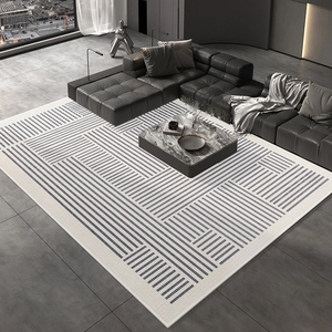 Detail of modern navy blue geometric area rug with white lines on a grey tile floor