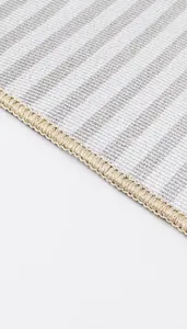 Detail of reinforced double-stitched edges on the gray striped Christmas door mat