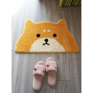 Detail of Shiba Inu shaped faux cashmere mat with fluffy pink slippers on wooden floor