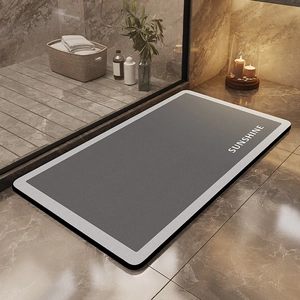 Close-up of a modern dark grey non-slip bathroom mat with Sunshine lettering on marble floor
