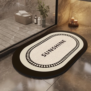 Close-up of oval marble diatom mud bath mat with Sunshine text on stone floor