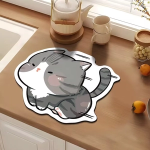 Close-up of cat-shaped absorbent mat on wooden counter with teapot and ceramic cups