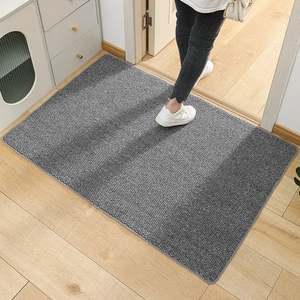 Dark gray sisal-style rectangular doormat with pineapple texture on light wood floor