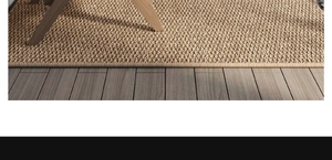 Close-up of tight sisal weave rug with durable striped edges on wooden floor