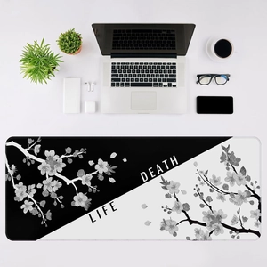 Top view of large black and white desk mat with cherry blossoms and Life Death theme