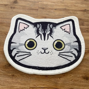 Vue détaillée d'un tapis pelucheux en forme de chat en fausse cachemire gris et blanc doux