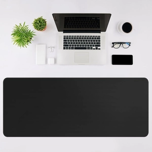 Top-down view of large black desk mat with stitched edges in a minimalist office setup