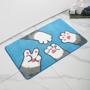 Close-up of fluffy blue bathroom mat with cute cartoon cat paw prints and soft texture