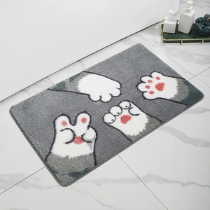 Detail of grey bathroom mat with cute white cat paw prints on marble floor