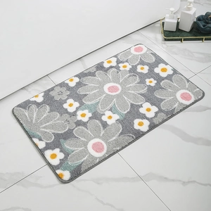 Close-up of soft daisy pattern bath mat on marble floor with luxury bathtub background