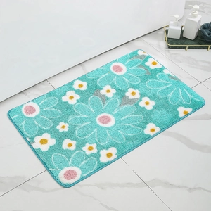 Close-up of soft floral bath mat with blue daisy pattern on white marble floor