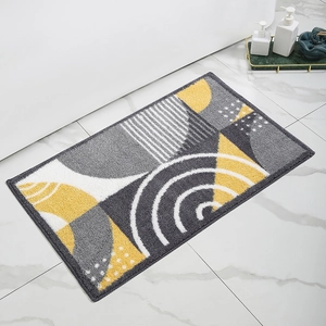 Detail of geometric bath mat with gray and yellow patterns on white marble floor