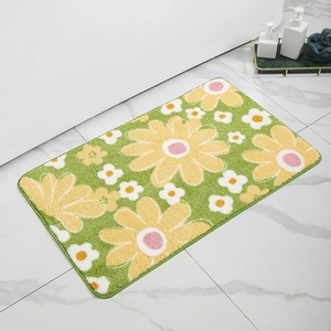 Detail of plush bathroom mat featuring large yellow daisy pattern on a green background