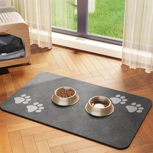 Detailed view of dark grey pet feeding mat with paw prints on a wooden floor
