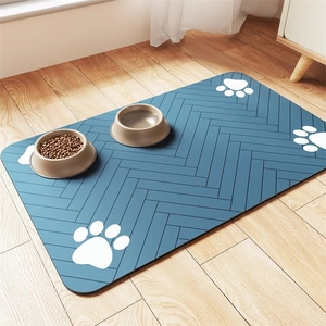 Close-up of a blue diatomaceous earth pet feeding mat with white paw prints on wood floor