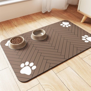 Waterproof pet feeding mat with paw prints and herringbone pattern on light wood floor
