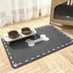Detail of grey diatom mud pet feeding mat with bone pattern on herringbone wood floor