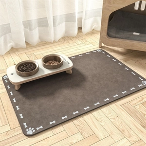 Close-up of brown diatom mud pet feeding mat with bone patterns on wooden floor
