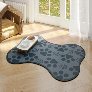 Detail of bone-shaped pet feeding mat with paw prints on a wooden floor