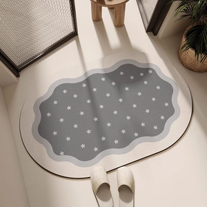Détail du tapis ovale en terre de diatomée avec étoiles et bordure ondulée maison
