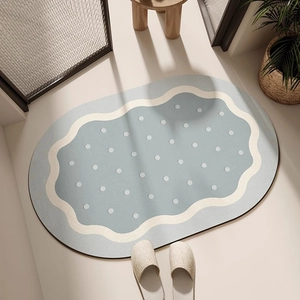Détail du tapis de bain ovale en terre de diatomée avec bordure ondulée et points