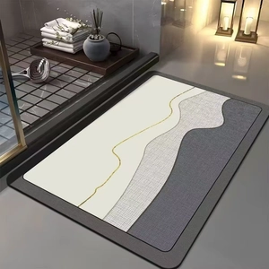 Detail of minimalist absorbent diatomite bath mat with grey wavy texture and gold line accent