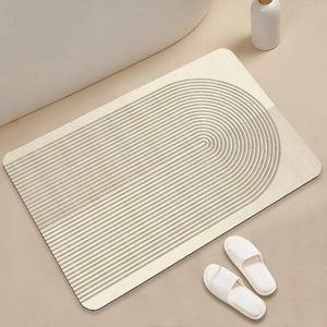 Detail of beige bath mat with 3D concentric U-shaped texture and non-slip surface