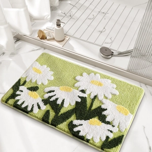 Macro detail of tufted grass-green bathroom rug featuring white daisy patterns and soft fiber