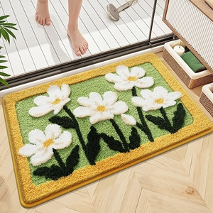 Floral tufted bath mat with daisy pattern and soft green microfiber surface