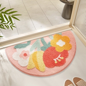 Detailed close-up of pink semi-circle tufted bath mat with colorful floral pattern